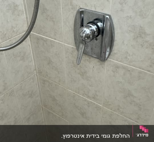 ברז מקלחת על קיר אריחים